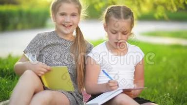 可爱的女孩一起在户外做作业。 他们在放学后获得知识。